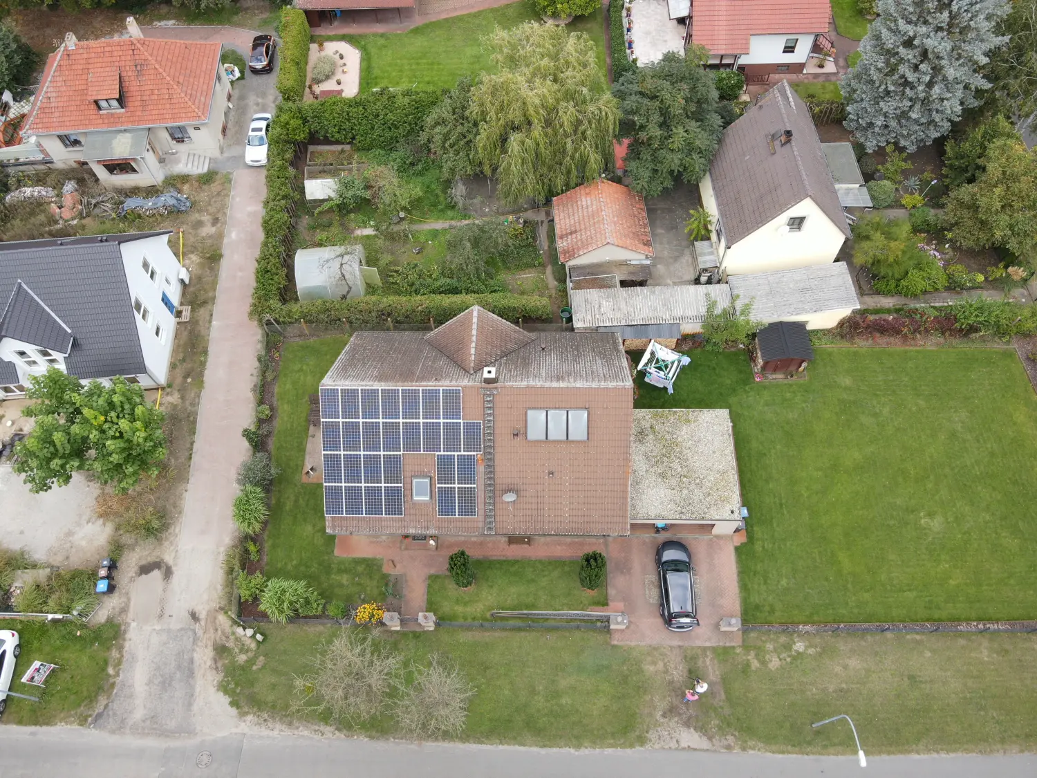 Drohnenblick, Luftbildaufnahme eines Hauses mit Solarplatten auf dem Dach 